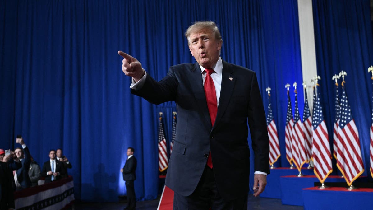 Donald Trump points as he walks across a stage during a rally in Perry, Georgia.