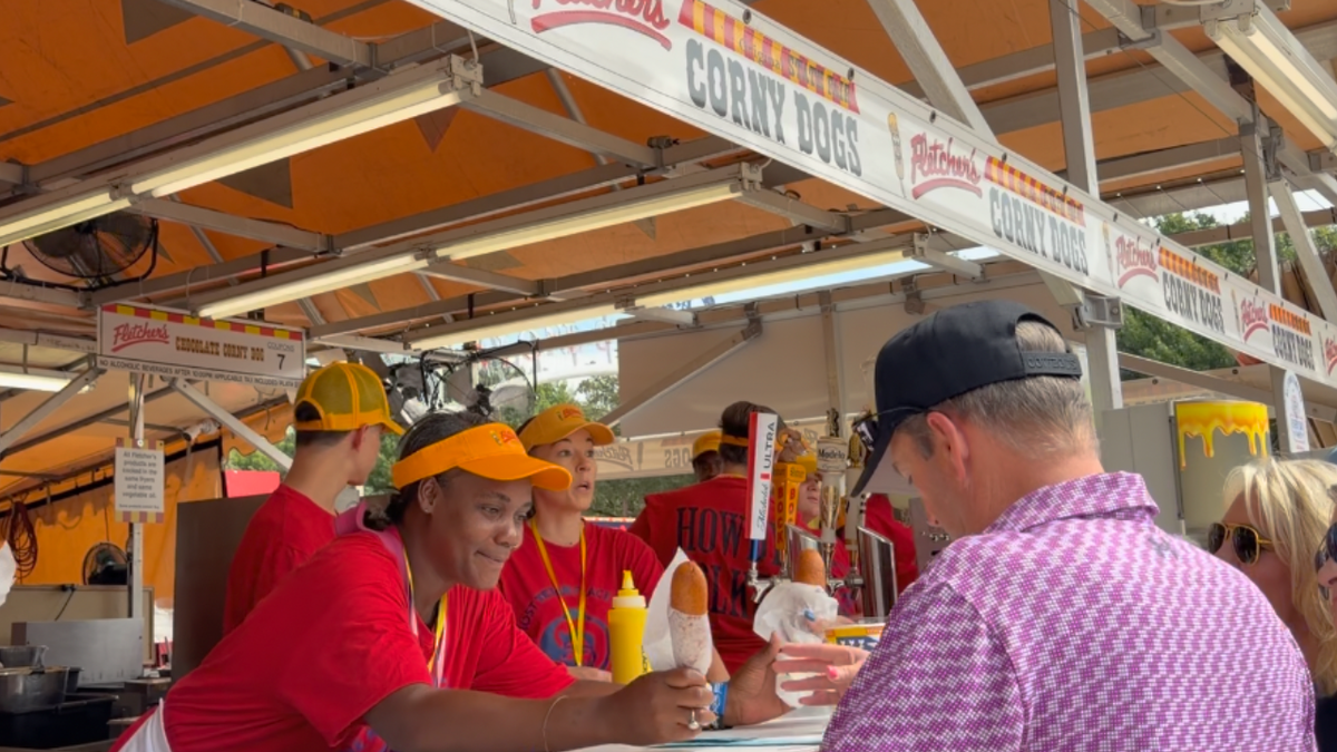 An employee hands corny dogs to patrons at the Texas State Fair on September 26, 2026 in Dallas, Texas.