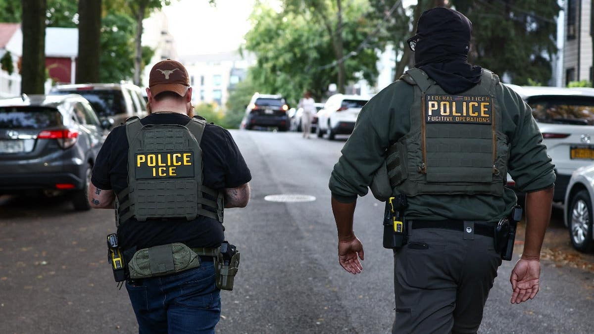 Federal agents walk near the scene where a man was shot by an ICE agent in New York City.