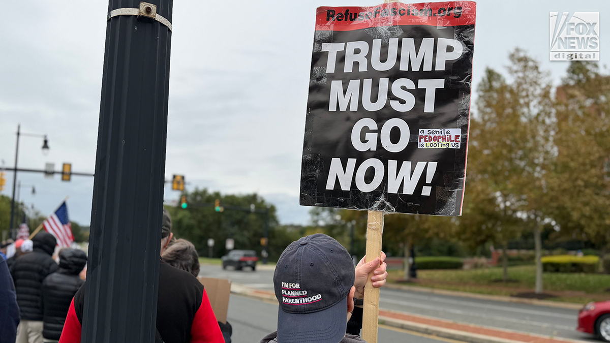 Protesters hold signs during the 