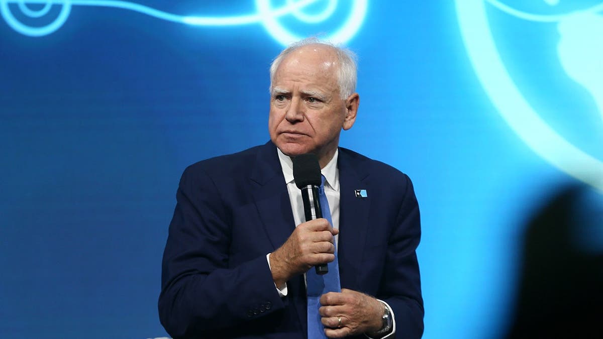 Tim Walz speaks at a podium during the Austrian World Summit climate conference in Vienna.