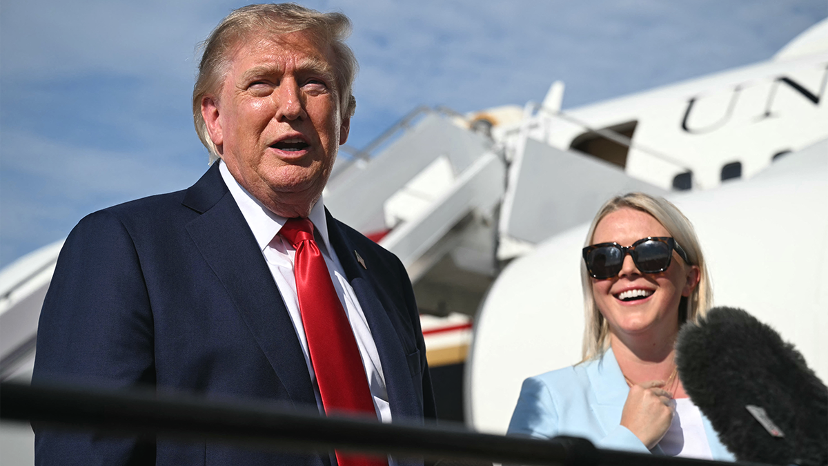President Donald Trump speaks to reporters alongside Karoline Leavitt.