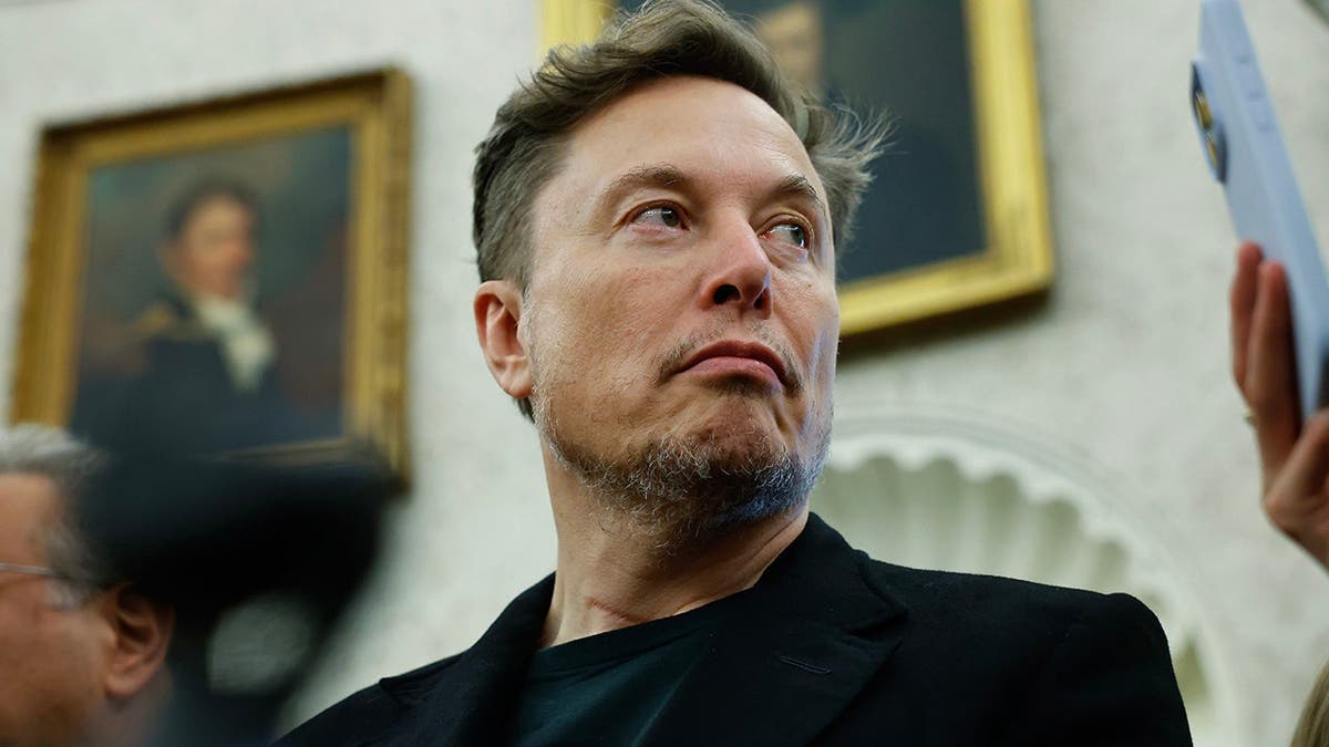 Elon Musk listens as President Trump and President Ramaphosa answer reporters' questions in the Oval Office.