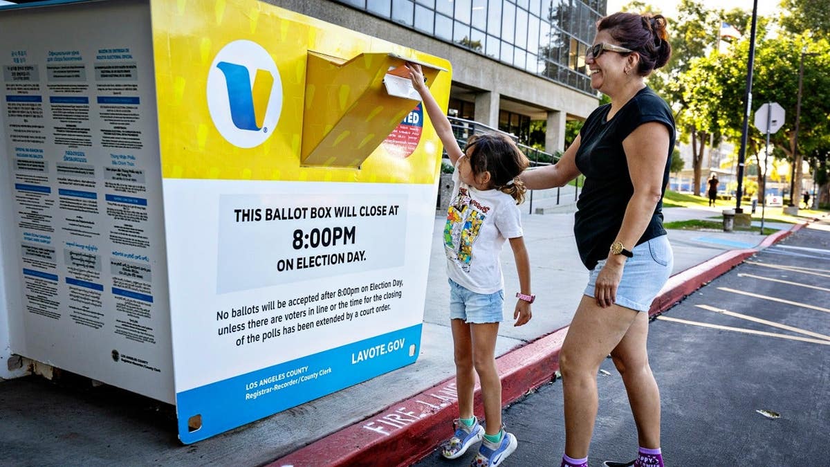 A woman drops off her midterm ballot at a receptacle in Los Angeles, California.